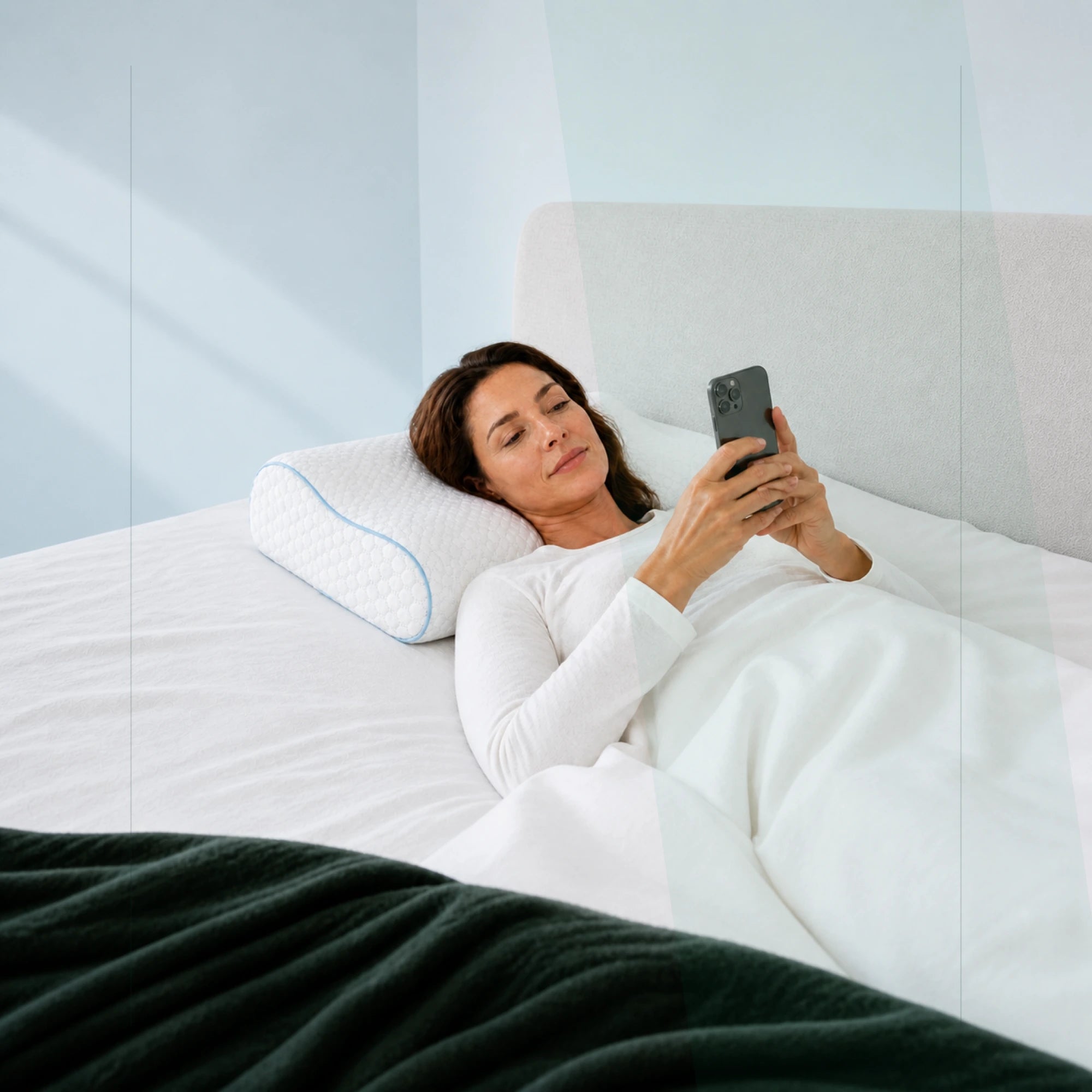 Frau nutzt vor dem Schlafen die PREVURA App auf dem ERGO PILLOW